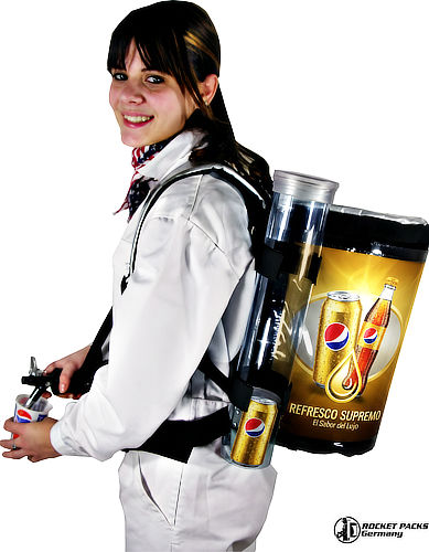Un vendedor promocionando una marca de refrescos con una mochila dispensadora Rocketpacks en una feria comercial, interactuando con clientes y sirviendo muestras gratuitas de bebidas refrescantes.